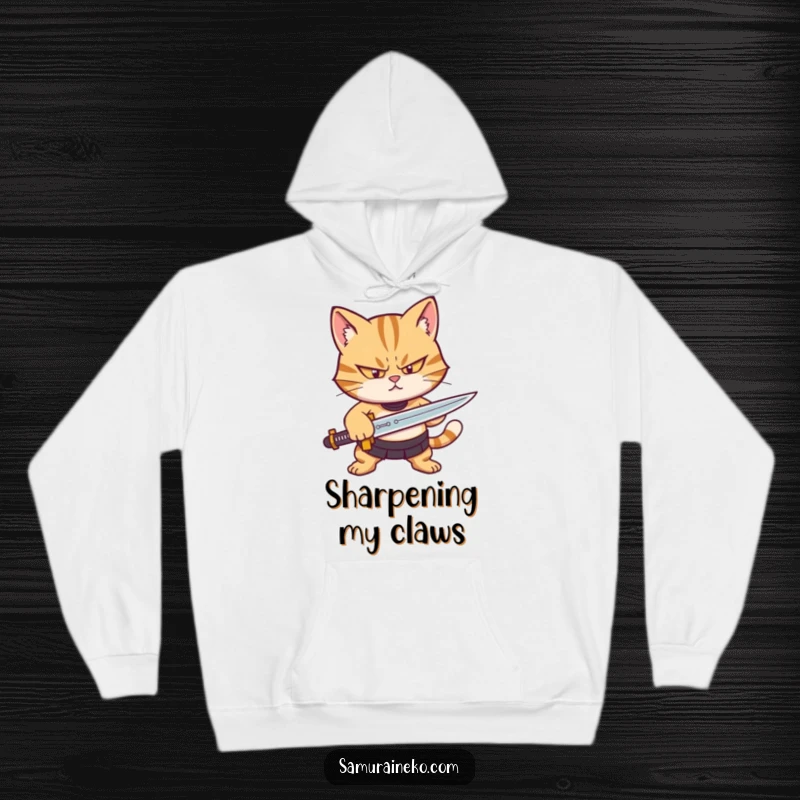 Funny hoodie featuring a focused cat character intently sharpening a tiny sword, perfect for a humorous, cozy look.
