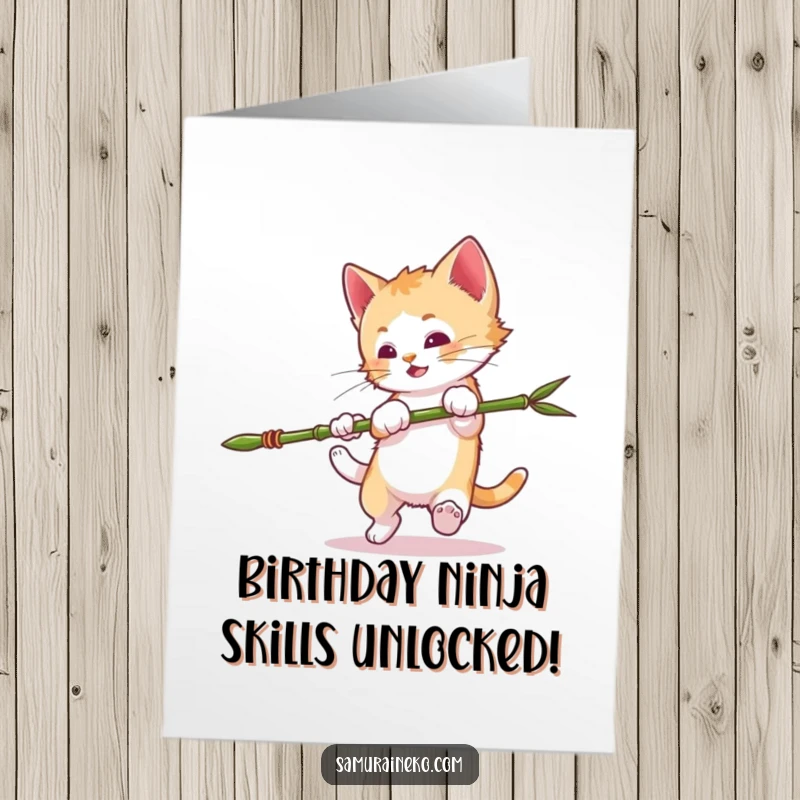Funny Free Printable Birthday Card of a mischievous kitten attempting a somersault while clutching a miniature bamboo spear, ready for action.